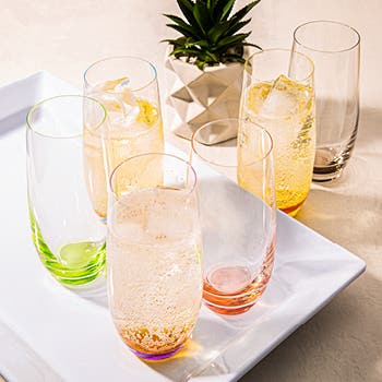 various coloured plastic glasses on a tray and tabletop