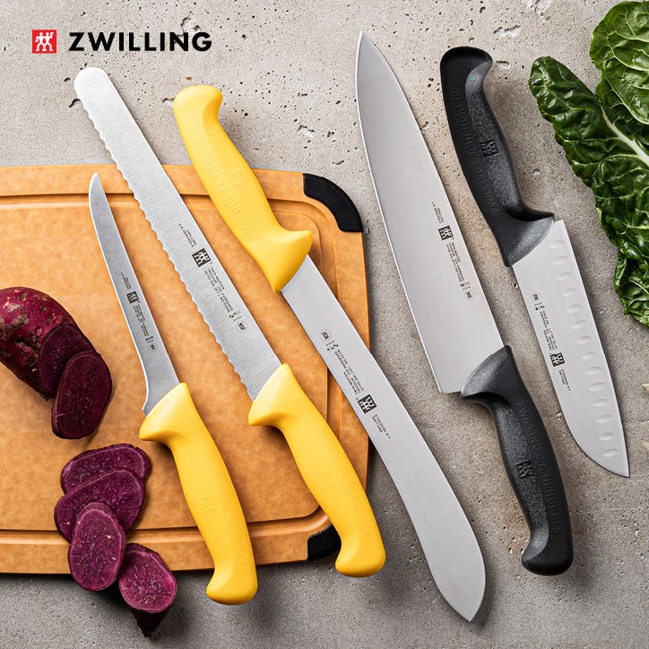 yellow and black handle knives on a cutting board with sliced radish