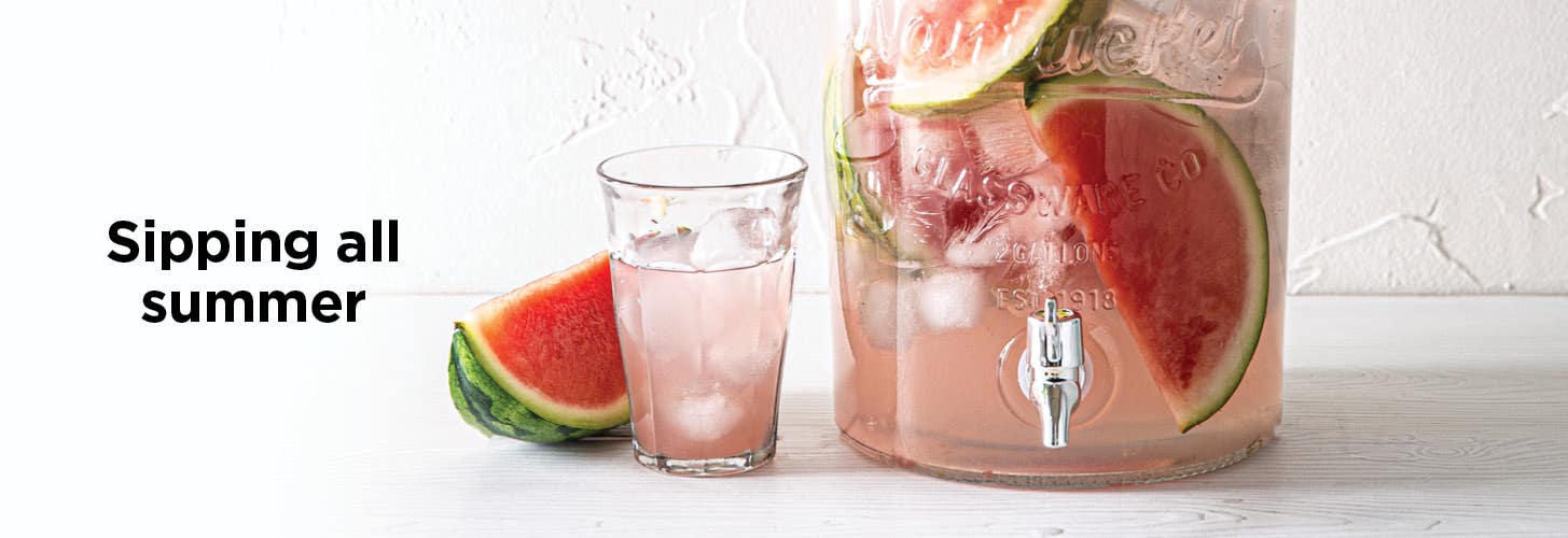 Sipping all summer. close-up view of a glass beverage dispenser filled with watermelons chunks and pink liquid